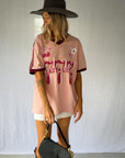 the Lucky Girl Tee is all about confidence, intuition, and calling in good things. Inspired by lucky motifs and the angel number 777, this women’s graphic tee blends playful symbolism with a bold, feminine edge. Pink base with burgundy trim for a flattering contrast. Jersey style vintage cotton.
The artist hand drawn art western-style numbers and star detailing, finished with cherries, playing cards and dice graphics for a nostalgic, Americana-inspired feel.