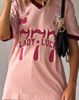 the Lucky Girl Tee is all about confidence, intuition, and calling in good things. Inspired by lucky motifs and the angel number 777, this women’s graphic tee blends playful symbolism with a bold, feminine edge. Pink base with burgundy trim for a flattering contrast. Jersey style vintage cotton.
The artist hand drawn art western-style numbers and star detailing, finished with cherries, playing cards and dice graphics for a nostalgic, Americana-inspired feel.